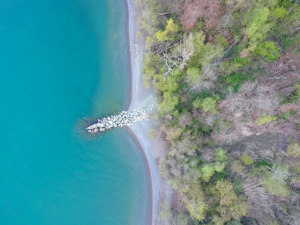 Top view eye bird aerial minimal photo of green blue calm lake water and green spring land with stones, lake Ontario, Canada, North America.