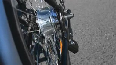 Elektrikli bisiklet motor spin kapatın. E bisiklet motor rotasyon güneşli yaz günde ufak olmadan sürme iken. Ayrıntılarda elektrikli tekerlekli. 