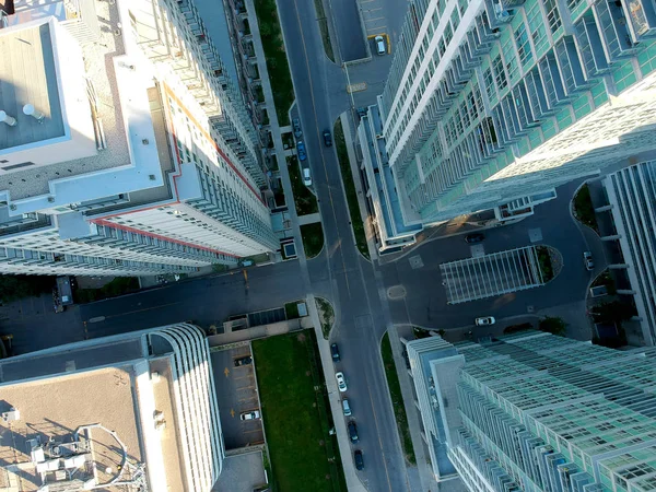 Aerial view of residential skyscrapers made of glass in the city from the top. Below is the road intersection. Housing development and infrastructure concept in modern American city.