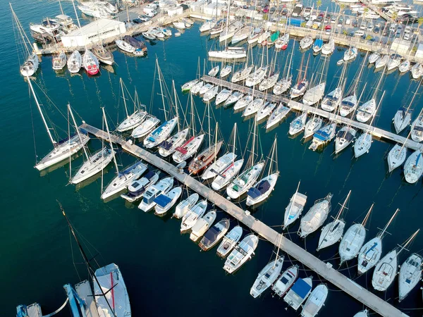Aerial bird eye view of Adriatic coast in Croatia Split beach harbour. European early evening sun, summer day with boats and yachts in calm water. Marina dock with boats, motorboats floating on water.