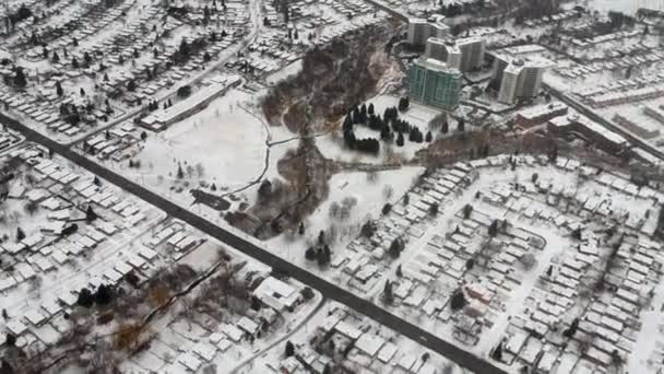 Légi drón kilátás utak és házak téli táj. Winter City utcák madártávlatból. A hó borította épületek felső perspektívája. Hóval borított utak, gyepek, autók és fák felülről.