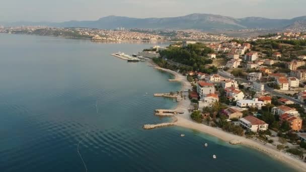 朝スプリット クロアチア 落ち着いたヨーロッパの緑の山々 の下でかなり観光職業ホテル海辺近くの海岸沿い村で風光明媚な空中の鳥ビュー — ストック動画
