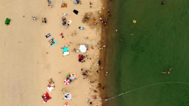 Güzel temiz suda yüzen turist ile kumlu plaj havadan görünümü. İnsanlar güneşlenme tropikal plaj yaz seyahat üzerinde yalan üstten görünüm kuş bakışı tatil.