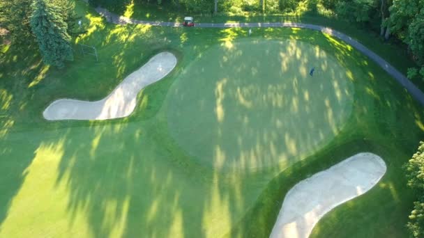 Terrain de golf avec deux joueurs le soir. Vue d'oiseau d'oeil du ciel. Images aériennes de la forêt et du terrain de golf .