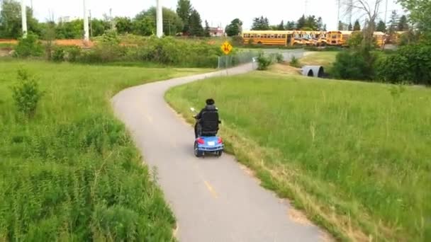 障害者は障害者や 高齢者のための電動モビリティ スクーターを運転します 空中後ろから障害映像運動レクリエーションの電気能力車両 アクセシビリティの概念 — ストック動画