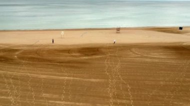 Hava rüzgarlı gün uçurtma ile oynayan çocuklar ile deniz kıyısında su kumlu plaj sahil uçan.