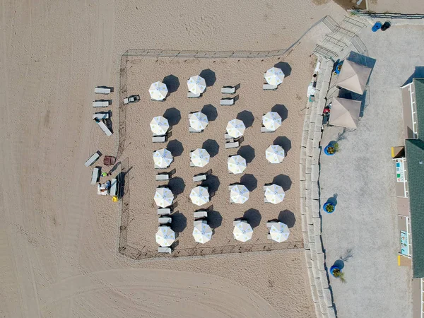 Vue aérienne de la plage étonnante avec des parasols blancs. Préparatifs des personnes — Photo