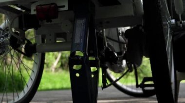 Mavi lastik eldivenli bisikletçi yaz günü dışarıda elektrikli bisiklet arka tekerleği temizliyor. Yavaş motorlu dolly çekim hareketi, Aşağıdan kaydırıcı kamyon yan hareketi kapatın. 4k