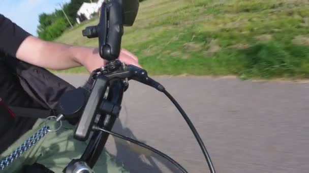 Unik vy över cyklistens handtag på nära håll. Snorricam rigg. Hand Biker håller och skjuter bromsen. Ombord actionkamera fäst på riggen till cykeln. Ovanligt perspektiv. 4K. — Stockvideo