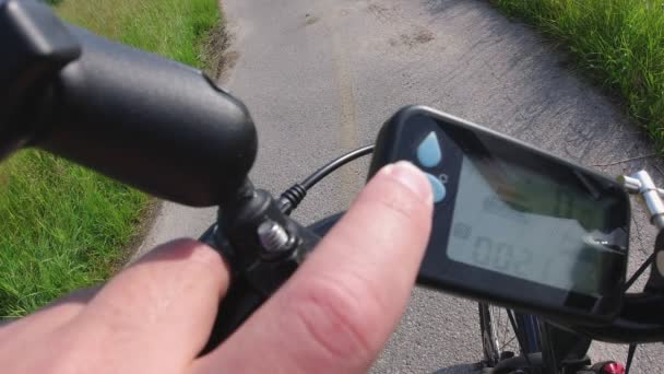 Rowerzysta obracając rower rowerowy lub elektryczny i naciskając przycisk na kontrolerze e Bike. Wbudowana kamera akcji skupia się na drodze. Widok z perspektywy pierwszej osoby POV. 4K. — Wideo stockowe