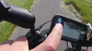 Bisikletçi ebike veya elektrikli bisiklet mesafe kontrol ve e bisiklet denetleyicisi düğmesine basarak. Onboard aksiyon kamerası yolda odak. Birinci şahıs perspektifinden görünüm Pov. 4k.