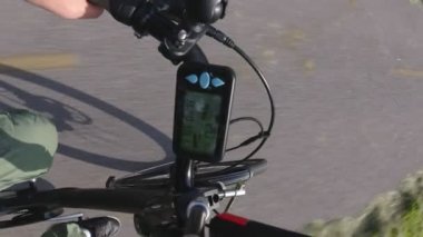 Şehir e bisiklet veya yaz aylarında park parça yolda sürme elektrikli bisiklet. Birinci şahıs perspektifinden Pov'u aksiyon kamerasıyla elektrik hız göstergesine veya güç seviyesine sahip kontrolöre görüntüleyin. 4k.