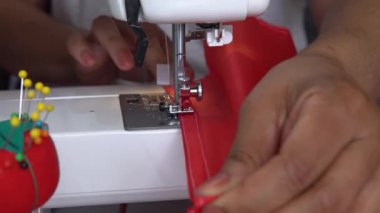 Kuzey Amerikalı kadın Kanada kırmızı ve beyaz bayrak dikiyor. 1 Temmuz, Kanada günü için hazırlık. İş sürecinde ellerin, dikiş makinesinin, iplik ve dantelin, el yapımı, makine iğnesinin kapatılması. 4k.