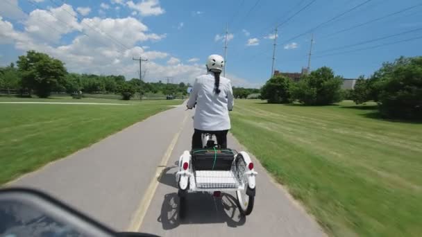 Mujeres jóvenes montando en bicicleta o triciclo, vista desde atrás y seguir POV. Mujer ciclista relajándose en el paseo de verano. Actividad en bicicleta en Toronto, Ontario, Canadá, parque de la ciudad. 4k . — Vídeos de Stock