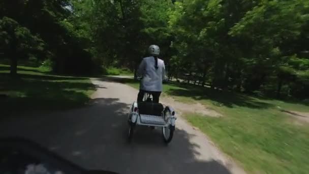 自転車やトライクに乗る若い女性は、後ろから見て、Povに従ってください。夏の乗り物でリラックスする女性サイクリスト。トロント、オンタリオ州、カナダ、都市公園での自転車活動。4k. — ストック動画