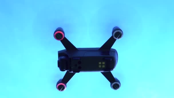 Drone vliegt in de lucht op lage hoogte tegen een blauwe lucht en vliegt snel. Moderne nieuwe technologie. Beelden van het vliegtuig van onderaf, ongewoon uitzicht. Vliegende quadcopter hierboven. Hobby. 4k. — Stockvideo