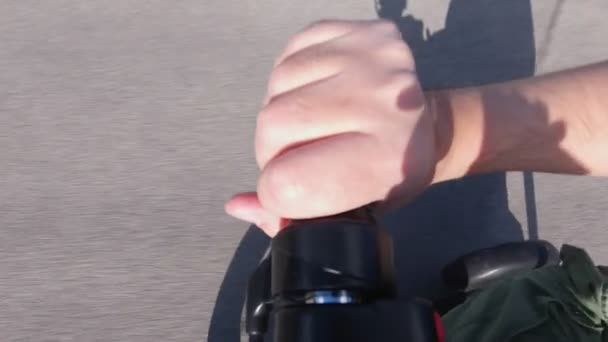 Uniek uitzicht op de gehandicapte persoon op de elektrische gemotoriseerde scootscooter holding voor handvat handvatten en Throttle om kracht te geven aan de motor, close-up. Recreatief elektrisch vermogen voertuig. Actie camera. — Stockvideo