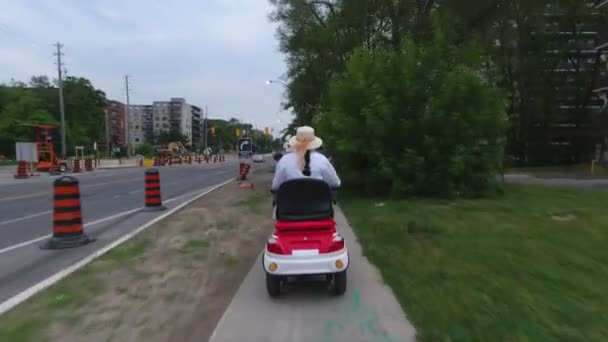 Handicapés conduisant un scooter de mobilité motorisé pour personnes âgées ou handicapées. Véhicule récréatif de capacité électrique pour le mouvement de séquences handicapées de derrière la caméra d'action. Concept d'accessibilité . — Video