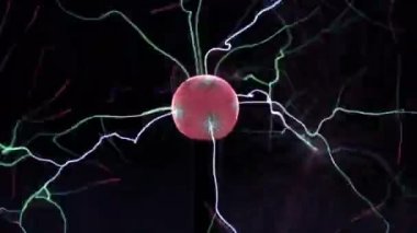 Plazma topu lamba yakın, siyah arka plan üzerinde toptan elektrik ışınları hareket. Elektrik ile Tesla Coil deneyi. Renklerde güzel dinamik soyut ışık arka plan.
