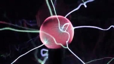 Plazma topu lamba yakın, siyah arka plan üzerinde toptan elektrik ışınları hareket. Elektrik ile Tesla Coil deneyi. Renklerde güzel dinamik soyut ışık arka plan.