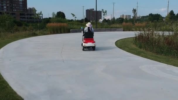 都市公園の電動スクーターに乗った女性たち 環境に配慮した電力輸送を推進 アクティブな大人のライフスタイル — ストック動画