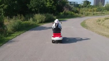 Engelliler ve yaşlılar için bir motorlu hareketlilik scooter sürüş özürlü. Eğlence elektrik yeteneği araç özürlü görüntüleri hareket hava arkasından için. Erişilebilirlik kavramı.