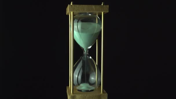 空気中に浮かぶか 砂時計を浮かべるクローズアップ 時間の概念を渡す ガラス球根を通って底部まで走る1時間のガラス砂 試験の概念を終了します ゆっくりと回転する — ストック動画
