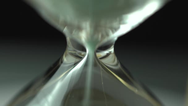 1時間のガラスを流れる砂の極端なクローズアップビュー 砂時計中央のスーパークローズアップ クラシックサンドグラスタイマー — ストック動画