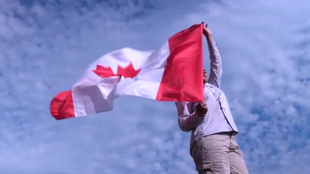 Mujer canadiense feliz de pie con la bandera de Canadá ondeando en la hora dorada noche lightning.Cheerful ciudadano adulto negro mujer orgullosa y sosteniendo la bandera nacional con hoja de arce rojo . — Vídeo de stock