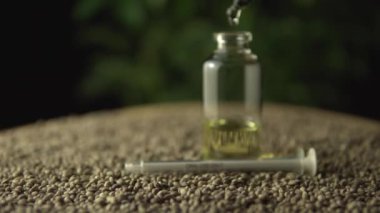 Pipette damlaları cbd yağı içerken kayıyor ve odaklanıyor. Kenevir tohumlarının üzerinde cam kavanoz. Yeni nesil sağlık eczanesi tıbbi konsepti. Acı tedavisinde devrim ve iyileşme endişesi.