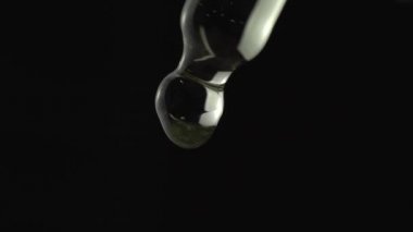 Tıbbi CBD yağ tedavisi ve üretimi kavramı. Pipetten yağ düşüşünün makro görüntüsü çok yakın. Doğal ilaç damlacıkları. Alternatif tıp. Yeni çağ sağlık eczanesi ve refah.