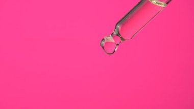 Kenevir bitkisinin biyolojik ve ekolojik yağına aşırı dozda damlacık pipetini yakın çekim makrosu. İlaç bitkisel cbd yağı, organik ilaç konsepti, pembe arka plan..