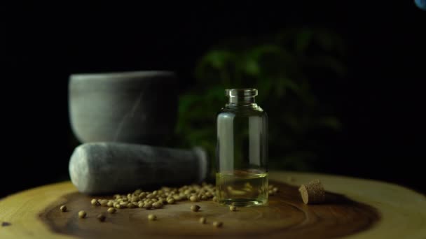 Macro close up de pipeta de gotas dosagem de óleo de cbd de ervas no frasco pequeno na mesa de anel de árvore círculo de madeira com argamassa, pilão e sementes de cânhamo. Legalização do conceito de marijuana medicinal . — Vídeo de Stock