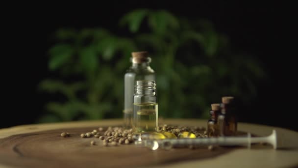 Close look of rotation or spinning pharmaceutical medical cbd oils and medications. Various medicine options on the wood table, such as pills and oils in the jars for oral use. Cannabis hemp plant. — Stock Video