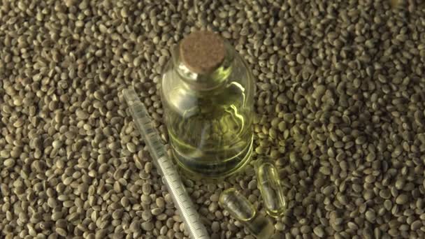 Very close view of CBD oil, oral syringe, pills for anxiety and stress relief near the glass jar on the wood circle tree ring table with ripple line pattern. Revolution in pain treatment and healing. — Stock Video