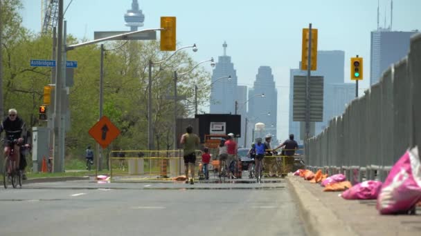 Toronto, Ontario, Canadá - 24 de mayo de 2020 Multitud de ciclistas, corredores y caminantes en las carreteras de la ciudad durante la pandemia de COVID 19. Distanciamiento físico y práctica activa del estilo de vida. Instalaciones temporales . — Vídeo de stock