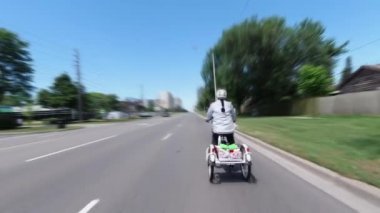 Şehir merkezinde elektrikli bisiklet süren bir bisikletçi var. Ekoloji konsepti. Yandan vurulmuş..