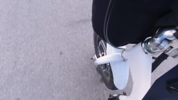 도시의 거리에서 전기 자전거를 타는 것입니다. 카메라 는 바퀴 의 모우터 나 전기 모우터 를 볼 수있다. 자연광. 닫아. — 비디오