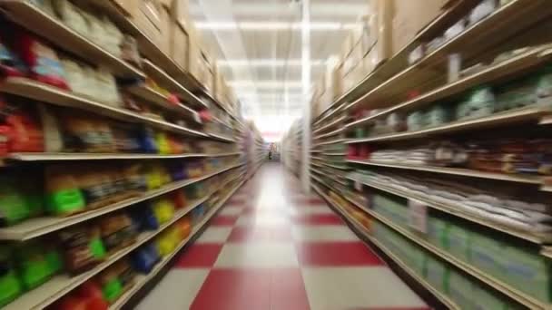 At the supermarket store pov action camera motion, through row section of the shop and different items merchandise. Front view shot. 4k. — Stock Video