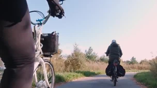 Пара путешественников на электрическом велосипеде, E-велосипеде или велосипеде на закате солнца в лесном парке. Осенняя природа природная молния. Активный туризм, поездки в парк апельсиновых листьев в Северной Америке. — стоковое видео