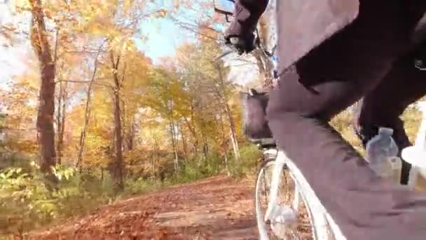 Wanderin, die bei Sonnenuntergang im Waldpark mit Elektro-Fahrrad, E-Bike oder Fahrrad unterwegs ist. Herbst Natur natürliche Blitze. Aktivtourismus, Fahrten im Orangenlaubpark in Nordamerika. — Stockvideo