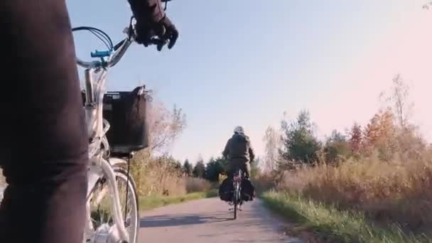 Viajantes casal andando em bicicleta elétrica, E-bike ou bicicletas ao pôr do sol no parque florestal. Natureza Outono relâmpago natural. Turismo ativo, passeios em folhas de laranja parque na América do Norte . — Vídeo de Stock