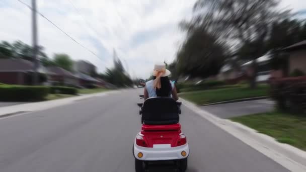 Vrouwen op een elektrische scooter in de stad. Autorijden van milieubewust energievervoer. Actieve volwassen levensstijl. — Stockvideo