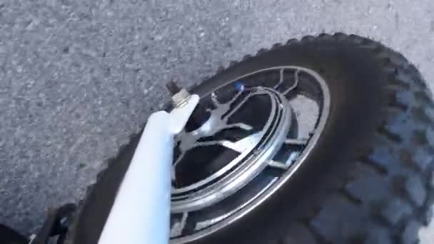 Elektrische fietsen rijden op de straten van de stad. Camera zicht op de motor of elektromotor van het wiel. Natuurlijke verlichting. Sluiten.. — Stockvideo