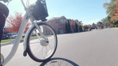 Şehir merkezinde elektrikli bisiklet süren bir bisikletçi var. Ekoloji konsepti. Yandan vurulmuş..