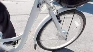 Bisikletçi pedalları çeviriyor ve pedal güç yardımıyla elektrikli bisiklete biniyor. E bisiklet teçhizatı yukarıdan yaklaşıyor. Çerçevedeki pil görüntüsü. Egzersiz ve sağlıklı bir yaşam tarzı..