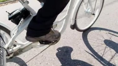 Şehir merkezinde elektrikli bisiklet süren bir bisikletçi var. Ekoloji konsepti. Yandan vurulmuş..