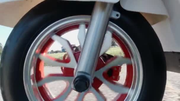 Gros plan d'une roue avant tournant sous le capot tout en conduisant un scooter électrique. Vue d'en haut. Transport alternatif moderne, option de mobilité populaire. — Video