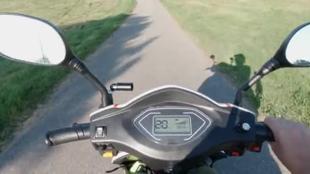 Paardrijden scooter door het groene gebied van het stadspark. Asfaltweg en zon. Vrijetijdsbesteding. Autorijden van milieubewust energievervoer. Actieve levensstijl. — Stockvideo