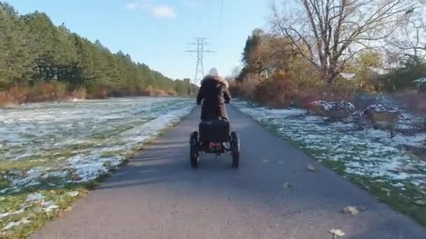 Vélo électrique ou électrique, prise de vue par derrière, concept écologique. Femme conduite trike électronique avec assistance au pédalage. Transport alternatif de puissance moteur. — Video